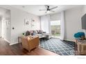 Bright living room with ceiling fan, grey sofa, and access to a private balcony at 4451 S Ammons St # 307, Littleton, CO 80123