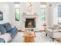 Cozy living room showcasing a fireplace, mantle, neutral paint, and large windows for natural light at 609 Corona Ct, Lafayette, CO 80026