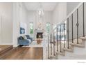 Bright, airy living room featuring a fireplace, high ceilings, and staircase with wrought iron balusters at 609 Corona Ct, Lafayette, CO 80026