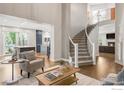 Open-concept living space showcasing a staircase, hardwood floors, and views to the kitchen and fireplace at 609 Corona Ct, Lafayette, CO 80026