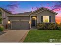 Inviting single-Gathering home featuring a gray exterior and well-manicured front yard at dusk at 6253 Black Mesa Rd, Frederick, CO 80516