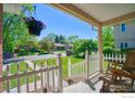 Inviting covered front porch with rocking chairs and a view of the landscaped yard at 729 Elm St, Denver, CO 80220