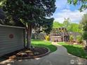 Serene backyard oasis with a hot tub under a pergola and lush green lawn at 731 Bowen St, Longmont, CO 80501