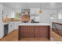 Modern kitchen with stainless steel appliances, a spacious island, and brick backsplash at 7736 Vallejo St, Denver, CO 80221