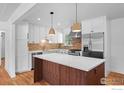 Bright kitchen with stainless steel appliances, white cabinets, and a wooden island at 7736 Vallejo St, Denver, CO 80221