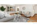 Cozy living room with hardwood floors, comfortable seating, a stylish rug, and ample natural light at 911 Timber Ct, Longmont, CO 80504