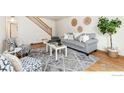 Comfortable living room with modern furniture, decorative accents, hardwood floors, and a staircase nearby at 911 Timber Ct, Longmont, CO 80504