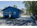 Charming blue single-story home with a well-maintained front yard and a driveway on the side at 934 6Th St, Berthoud, CO 80513