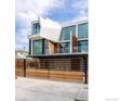 The modern home has a sleek white exterior, large windows, and a stylish horizontal wood fence at 944 Arapahoe Ave # A, Boulder, CO 80302