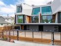 A modern home boasts a white exterior, large windows, and a horizontal wood fence at 944 Arapahoe Ave # A, Boulder, CO 80302