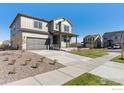 Charming two-story home featuring a covered porch, two car garage and a well manicured lawn at 9882 Cathay St, Commerce City, CO 80022