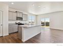 Modern kitchen with granite countertops, an island, and stainless steel appliances at 9902 Cathay St, Commerce City, CO 80022