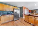 Open kitchen area with stainless steel refrigerator and plentiful cabinetry at 1086 Mockingbird St, Brighton, CO 80601
