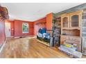 Spacious living area featuring hardwood floors, storage, and a unique accent wall at 1086 Mockingbird St, Brighton, CO 80601