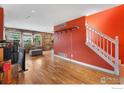 Bright living room with hardwood floors, stairway, and wooden wall accents at 1086 Mockingbird St, Brighton, CO 80601