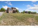 Large backyard with a deck and walkout basement, complemented by a white fence at 10970 E 150Th Pl, Brighton, CO 80602