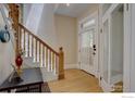 Bright foyer showcasing a staircase with decorative wood railings and an original entry door with glass panels at 1315 Gaylord St, Denver, CO 80206