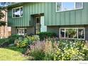 Well-maintained two-story home boasting green siding and a beautifully landscaped front yard with colorful flowers at 1350 Lehigh St, Boulder, CO 80305