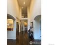 Bright foyer featuring hardwood floors, soaring ceilings, and arched doorways at 1613 Golden Bear Dr, Longmont, CO 80504