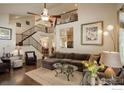 Spacious living room showcasing staircase, vaulted ceilings, and abundant natural light at 1613 Golden Bear Dr, Longmont, CO 80504