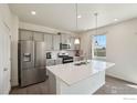 Modern kitchen with stainless steel appliances, gray cabinets, an island, and hardwood floors at 1800 Vantage Pkwy, Berthoud, CO 80513