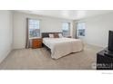 Spacious main bedroom with a large bed, soft carpet, and natural lighting through the windows at 1800 Vantage Pkwy, Berthoud, CO 80513