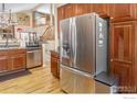 Kitchen view showcasing a stainless steel refrigerator and accents of the connecting living space at 2085 Tundra Cir, Erie, CO 80516