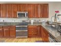 Cozy kitchen featuring granite counters, stainless steel appliances, and ample cabinet storage at 2085 Tundra Cir, Erie, CO 80516