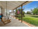 Inviting covered porch with a swing, offering a view of the expansive lawn at 2091 Tate Ave, Fort Lupton, CO 80621