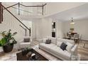 Bright living room with wooden floors, an elegant staircase, and comfortable furnishings at 2144 Santa Fe Dr, Longmont, CO 80504