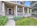 Inviting front porch with classic columns and well-kept landscaping at 2215 Parkview Dr, Longmont, CO 80504