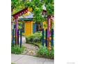 Quaint yellow house with colorful trim, surrounded by a garden and a decorative arched entrance at 2320 22Nd St, Boulder, CO 80304