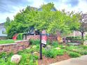 Well-maintained front yard with lush landscaping, mature trees, and a 'For Sale' sign, inviting potential buyers at 23570 E Holly Hills Way, Parker, CO 80138