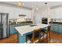 Bright kitchen with stainless appliances, subway tile backsplash, white cabinets and large island at 23570 E Holly Hills Way, Parker, CO 80138