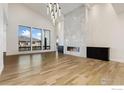 Bright living room with modern fireplace, hardwood floors, and views of the neighborhood at 2712 Bluewater Rd, Berthoud, CO 80513