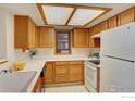Bright kitchen with ample counter space, wood cabinets, and a classic white refrigerator at 2800 Sundown Ln # 109, Boulder, CO 80303