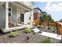 Inviting front porch with hanging chairs, complemented by a professionally landscaped front yard and concrete walkway at 308 Fickel Farm Trl, Berthoud, CO 80513