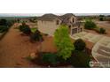 Sprawling property showcasing a well-maintained lawn, mature trees and a spacious driveway at 3106 Megan Way, Berthoud, CO 80513
