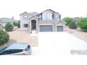 Well-maintained two-story home with a spacious driveway and manicured landscaping in a suburban neighborhood at 3106 Megan Way, Berthoud, CO 80513