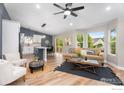 Bright living space featuring hardwood floors, a comfortable sofa, and a view of the backyard at 3557 Settler Ridge Dr, Mead, CO 80542