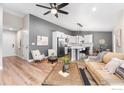 Open-concept living area with modern decor, light wood floors, and a stylish kitchen in the background at 3557 Settler Ridge Dr, Mead, CO 80542