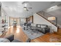 Open-concept living space featuring hardwood floors, modern staircase, and seamless flow to the dining area and kitchen at 3845 N Raleigh St, Denver, CO 80212