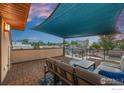 Relaxing rooftop deck featuring stylish outdoor furniture and a sun shade offering views of the surrounding neighborhood at 3845 N Raleigh St, Denver, CO 80212