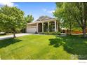 Beautiful home with a covered porch, stone accents, well-manicured lawn, and mature trees at 4444 Fireweed Trl, Broomfield, CO 80023