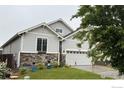 Charming single Gathering home with a well-manicured lawn, gray siding, and a two car garage at 563 Country Rd, Berthoud, CO 80513