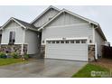 Charming single Gathering home with a well-manicured lawn, gray siding, and a two car garage at 563 Country Rd, Berthoud, CO 80513