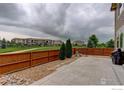 Fenced backyard with a concrete patio and lawn at 6356 Twilight Ave, Firestone, CO 80504