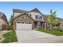 Charming home with a stone facade, two-car garage, and well-manicured lawn on a sunny day at 853 Jenny Ln, Berthoud, CO 80513