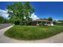 Well-maintained single-story home with lush green lawn and mature trees at 855 33Rd St, Boulder, CO 80303