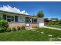 Charming single-story home with brick facade and attached garage with a green front lawn at 855 33Rd St, Boulder, CO 80303
